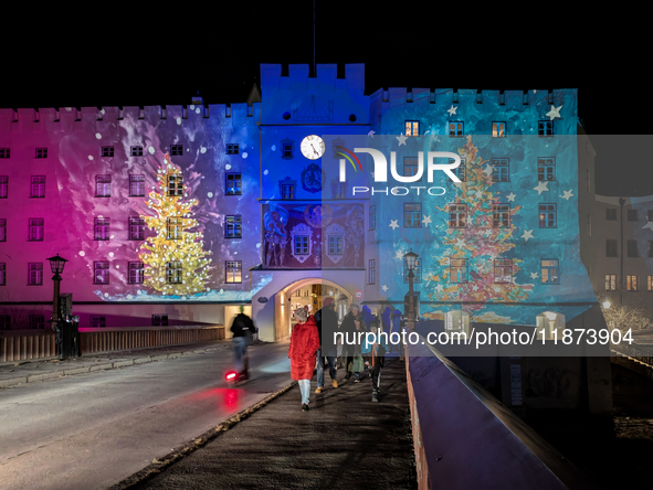 Historic buildings glow with colorful Christmas light projections in Wasserburg am Inn, Bavaria, Germany, on December 15, 2024. The historic...