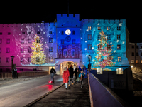 Historic buildings glow with colorful Christmas light projections in Wasserburg am Inn, Bavaria, Germany, on December 15, 2024. The historic...