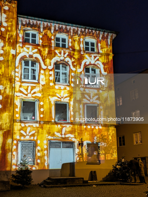 Historic buildings glow with colorful Christmas light projections in Wasserburg am Inn, Bavaria, Germany, on December 15, 2024. The historic...