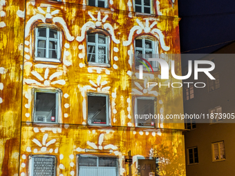 Historic buildings glow with colorful Christmas light projections in Wasserburg am Inn, Bavaria, Germany, on December 15, 2024. The historic...