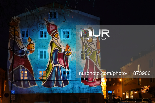 Historic buildings glow with colorful Christmas light projections in Wasserburg am Inn, Bavaria, Germany, on December 15, 2024. The historic...