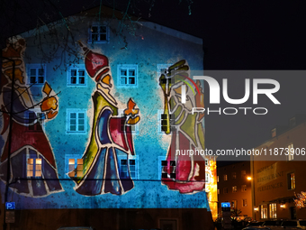 Historic buildings glow with colorful Christmas light projections in Wasserburg am Inn, Bavaria, Germany, on December 15, 2024. The historic...