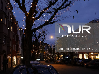 Historic buildings glow with colorful Christmas light projections in Wasserburg am Inn, Bavaria, Germany, on December 15, 2024. The historic...