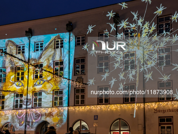 Historic buildings glow with colorful Christmas light projections in Wasserburg am Inn, Bavaria, Germany, on December 15, 2024. The historic...