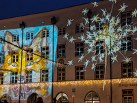 Historic buildings glow with colorful Christmas light projections in Wasserburg am Inn, Bavaria, Germany, on December 15, 2024. The historic...