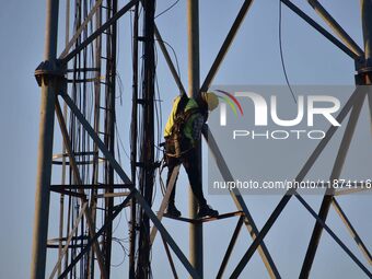 A telecom network engineer works on a mobile phone tower in Nagaon District, Assam, India, on December 16, 2024. (