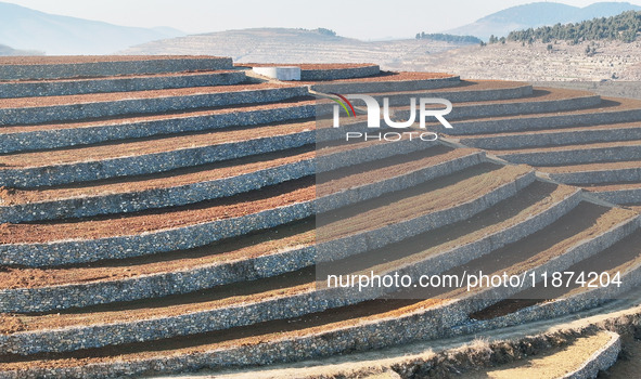 Stacked rice terraces formed by barren mountains are seen in Zaozhuang, China, on December 15, 2024. 