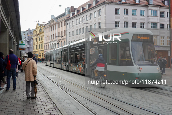 People are near a tram in Augsburg, Bavaria, Germany, on December 14, 2024. The Augsburg tramway is a vital part of the city's public transp...