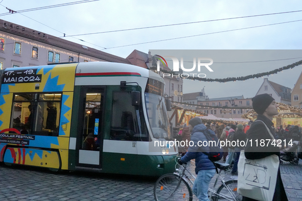 People are near a tram in Augsburg, Bavaria, Germany, on December 14, 2024. The Augsburg tramway is a vital part of the city's public transp...