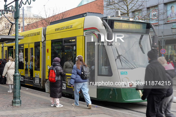 People are near a tram in Augsburg, Bavaria, Germany, on December 14, 2024. The Augsburg tramway is a vital part of the city's public transp...