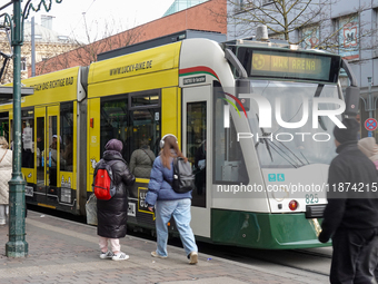 People are near a tram in Augsburg, Bavaria, Germany, on December 14, 2024. The Augsburg tramway is a vital part of the city's public transp...