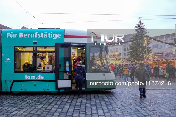 People enter a tram in Augsburg, Bavaria, Germany, on December 14, 2024. The Augsburg tramway is a vital part of the city's public transport...