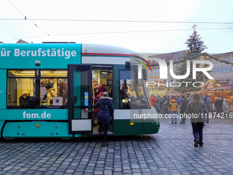 People enter a tram in Augsburg, Bavaria, Germany, on December 14, 2024. The Augsburg tramway is a vital part of the city's public transport...