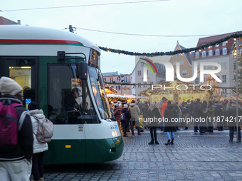 People are near a tram in Augsburg, Bavaria, Germany, on December 14, 2024. The Augsburg tramway is a vital part of the city's public transp...