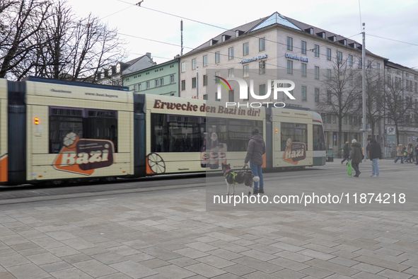 People are near a tram in Augsburg, Bavaria, Germany, on December 14, 2024. The Augsburg tramway is a vital part of the city's public transp...