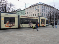 People are near a tram in Augsburg, Bavaria, Germany, on December 14, 2024. The Augsburg tramway is a vital part of the city's public transp...