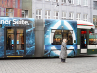 A woman passes a tram in Augsburg, Bavaria, Germany, on December 14, 2024. The Augsburg tramway is a vital part of the city's public transpo...