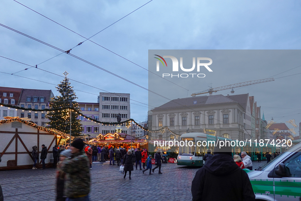 People are near a tram in Augsburg, Bavaria, Germany, on December 14, 2024. The Augsburg tramway is a vital part of the city's public transp...