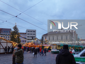 People are near a tram in Augsburg, Bavaria, Germany, on December 14, 2024. The Augsburg tramway is a vital part of the city's public transp...