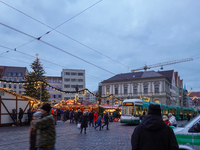 People are near a tram in Augsburg, Bavaria, Germany, on December 14, 2024. The Augsburg tramway is a vital part of the city's public transp...