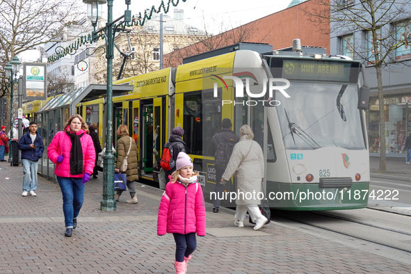 People are near a tram in Augsburg, Bavaria, Germany, on December 14, 2024. The Augsburg tramway is a vital part of the city's public transp...