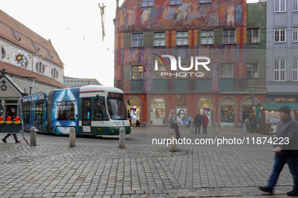 People are near a tram in Augsburg, Bavaria, Germany, on December 14, 2024. The Augsburg tramway is a vital part of the city's public transp...