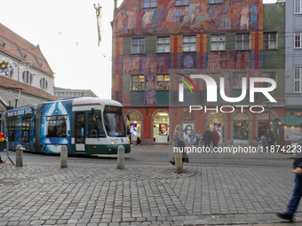 People are near a tram in Augsburg, Bavaria, Germany, on December 14, 2024. The Augsburg tramway is a vital part of the city's public transp...