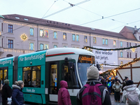 People are near a tram in Augsburg, Bavaria, Germany, on December 14, 2024. The Augsburg tramway is a vital part of the city's public transp...