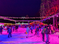 Families and people of all ages ice skate surrounded by vibrant lights and decorations in Wasserburg am Inn, Bavaria, Germany, on December 1...