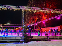 Families and people of all ages ice skate surrounded by vibrant lights and decorations in Wasserburg am Inn, Bavaria, Germany, on December 1...