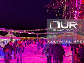 Families and people of all ages ice skate surrounded by vibrant lights and decorations in Wasserburg am Inn, Bavaria, Germany, on December 1...