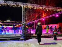 Families and people of all ages ice skate surrounded by vibrant lights and decorations in Wasserburg am Inn, Bavaria, Germany, on December 1...