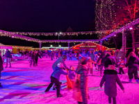 Families and people of all ages ice skate surrounded by vibrant lights and decorations in Wasserburg am Inn, Bavaria, Germany, on December 1...