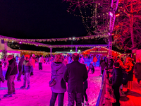 Families and people of all ages ice skate surrounded by vibrant lights and decorations in Wasserburg am Inn, Bavaria, Germany, on December 1...