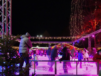 Families and people of all ages ice skate surrounded by vibrant lights and decorations in Wasserburg am Inn, Bavaria, Germany, on December 1...