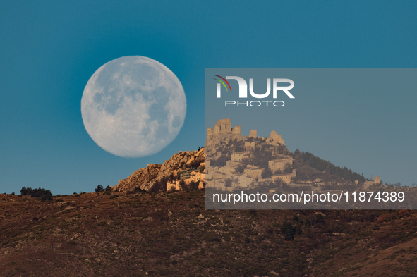 Cold full moon sets behind Rocca Calascio castle and village in Calascio, Italy, on December 16th, 2024. Celts renamed the december full moo...