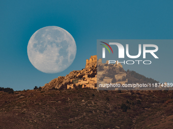 Cold full moon sets behind Rocca Calascio castle and village in Calascio, Italy, on December 16th, 2024. Celts renamed the december full moo...