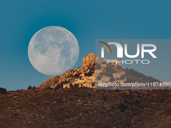 Cold full moon sets behind Rocca Calascio castle and village in Calascio, Italy, on December 16th, 2024. Celts renamed the december full moo...