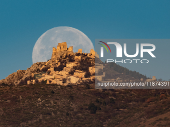 Cold full moon sets behind Rocca Calascio castle and village in Calascio, Italy, on December 16th, 2024. Celts renamed the december full moo...