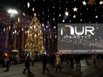 The main Christmas tree and New Year's illuminations are illuminated on Rustaveli Avenue as anti-government demonstrators gather outside the...