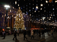 The main Christmas tree and New Year's illuminations are illuminated on Rustaveli Avenue as anti-government demonstrators gather outside the...