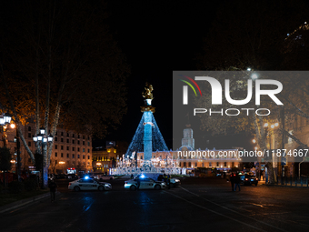 The main Christmas tree and New Year's illuminations are illuminated on Rustaveli Avenue as anti-government demonstrators gather outside the...