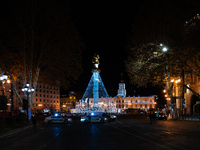 The main Christmas tree and New Year's illuminations are illuminated on Rustaveli Avenue as anti-government demonstrators gather outside the...