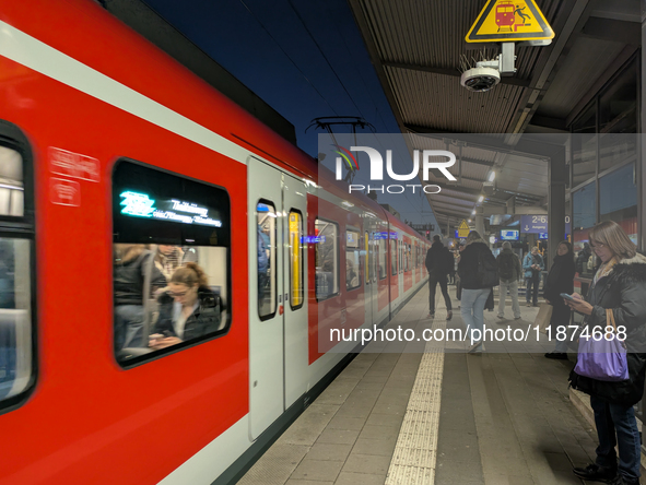 Commuters wait as an S-Bahn suburban train stops at Munich Pasing Station in Munich, Bavaria, Germany, on December 16, 2024. A suburban trai...