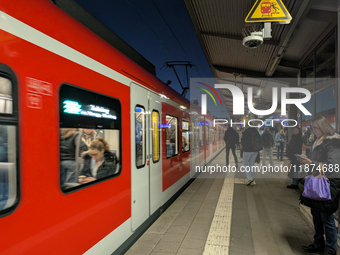 Commuters wait as an S-Bahn suburban train stops at Munich Pasing Station in Munich, Bavaria, Germany, on December 16, 2024. A suburban trai...