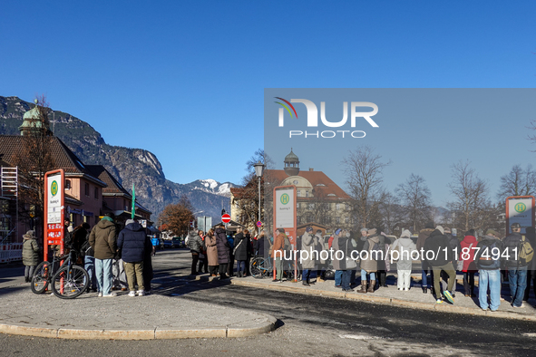 Travelers wait for a bus at Garmisch-Partenkirchen train station in Bavaria, Germany, on December 13, 2024. People gather at the bus stop lo...