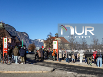 Travelers wait for a bus at Garmisch-Partenkirchen train station in Bavaria, Germany, on December 13, 2024. People gather at the bus stop lo...