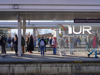 Travelers gather at the Garmisch-Partenkirchen train station in the Bavarian Alps, Germany, on December 13, 2024. The station is bustling wi...