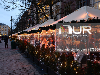 Christmas decorations are seen on a heated restaurant garden at the Main Square in Krakow, Poland on December 16, 2024. (