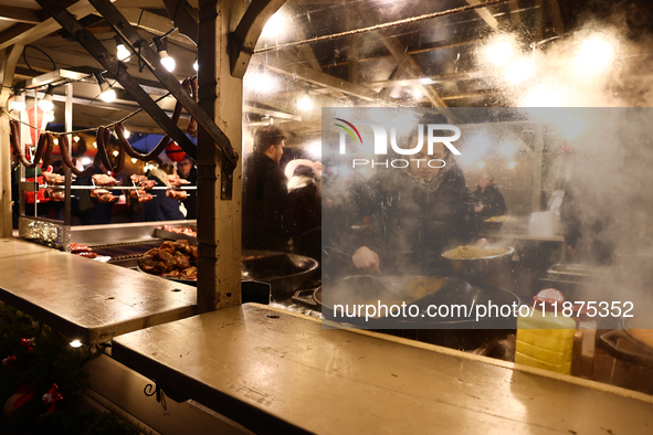 A person prepares food at the Christmas fair at Main Square in Krakow, Poland on December 16, 2024. 